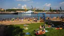 Orang-orang berjemur di tepi Sungai Moskva pada musim panas di Moskow, Rusia, Selasa (13/7/2021). Moskow dilanda gelombang panas bersejarah pada akhir Juni, dengan suhu mencapai rekor 120 tahun. (DIMITAR DILKOFF/AFP)