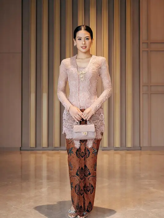 Ia memadukan kebayanya dengan kain batik warna coklat dan mini bag warna senada dengan kebayanya dari Chanel [@maudyayunda]