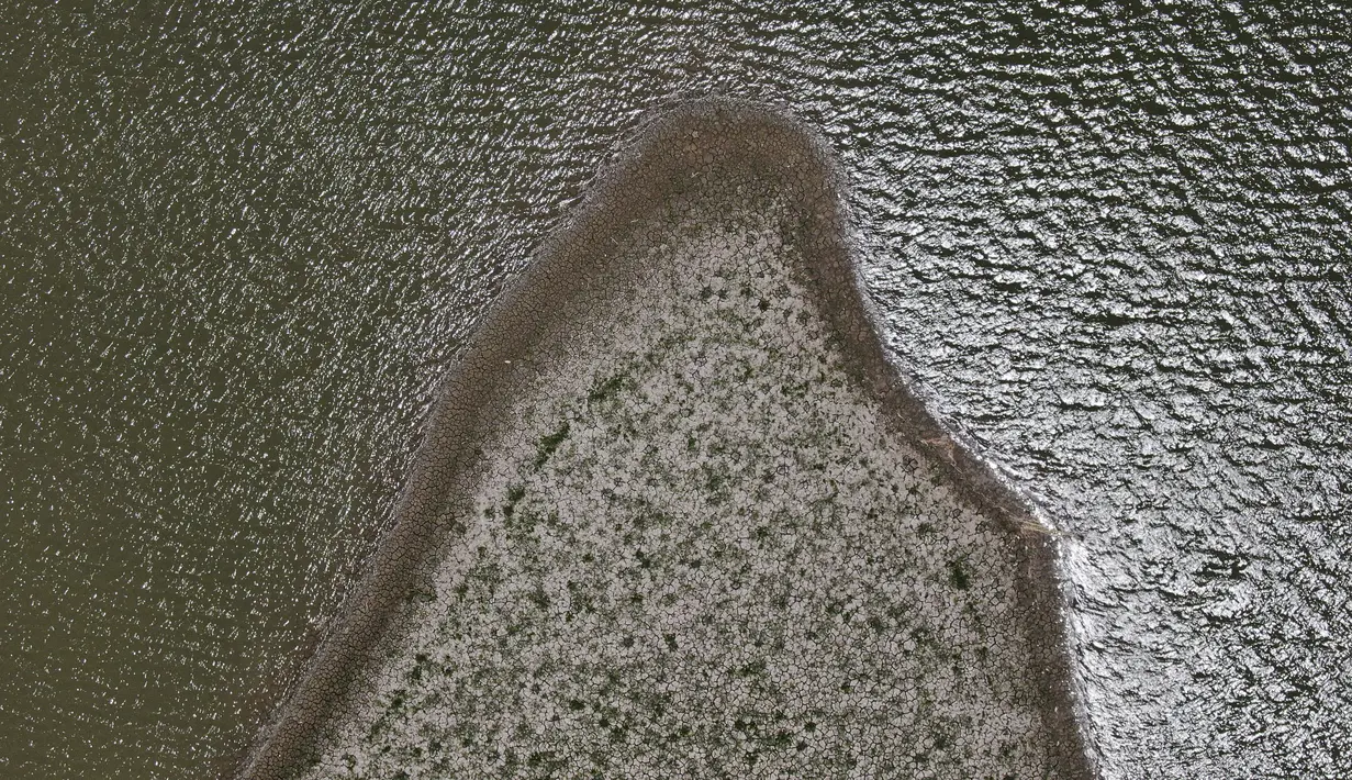 Lahan kering dan retak terlihat di Waduk Boca yang memasok air ke kota utara Monterrey yang hampir kering karena bagian utara Meksiko terkena kekeringan hebat, di Santiago, Meksiko (9/7/2022). Pemerintah setempat mulai membatasi pasokan air di bulan Maret, sebagai kombinasi dari kekeringan hebat. (AP Photo/Fernando Llano)