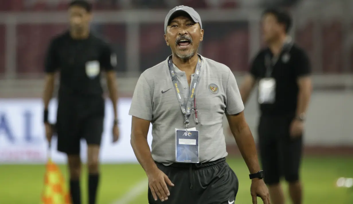 Pelatih Timnas Indonesia U-19, Fakhri Husaini, memperhatikan pemainnya saat melawan Timnas Korea Utara pada laga Kualifikasi AFC U-19 2020 di Stadion GBK, Jakarta, Minggu (10/11). Indonesia U-19 berhasil menahan imbang 1-1 DPR Korea. (Bola.com/Yoppy Renato)