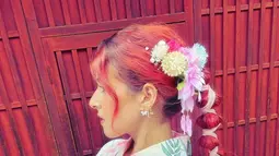 Selalu perfeksionis dalam setiap penampilan, Tasya juga merias rambutnya dengan indah. Rambut merahnya diikat dari ujung rambut sampai membentuk ikatan panjang. Di bagian atas, ibu satu anak itu juga menyisipkan berbagai bunga warna-warni yang mempercantik rambutnya. (Liputan6.com/IG/@tasyafarasya)