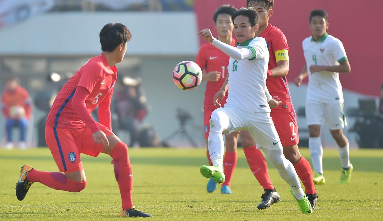 Gelandang Indonesia U-19, Muhammad Iqbal, berusaha melewati pemain Korea Selatan (Korsel) pada kualifikasi Piala Asia U-19 2018 di Stadion Paju, Sabtu (4/11/2017). Korsel menang 4-0 atas Indonesia. (AFP/Kim Doo-Ho)