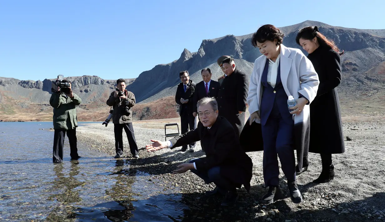 Presiden Korea Selatan Moon Jae-in ditemani istrinya, Kim Jung-sook melihat air kawah Gunung Paektu, Kora Utara, Kamis (20/9). Gunung Paektu merupakan gunung berapi yang dianggap sakral di Korea Utara. (Pyongyang Press Corps Pool via AP)