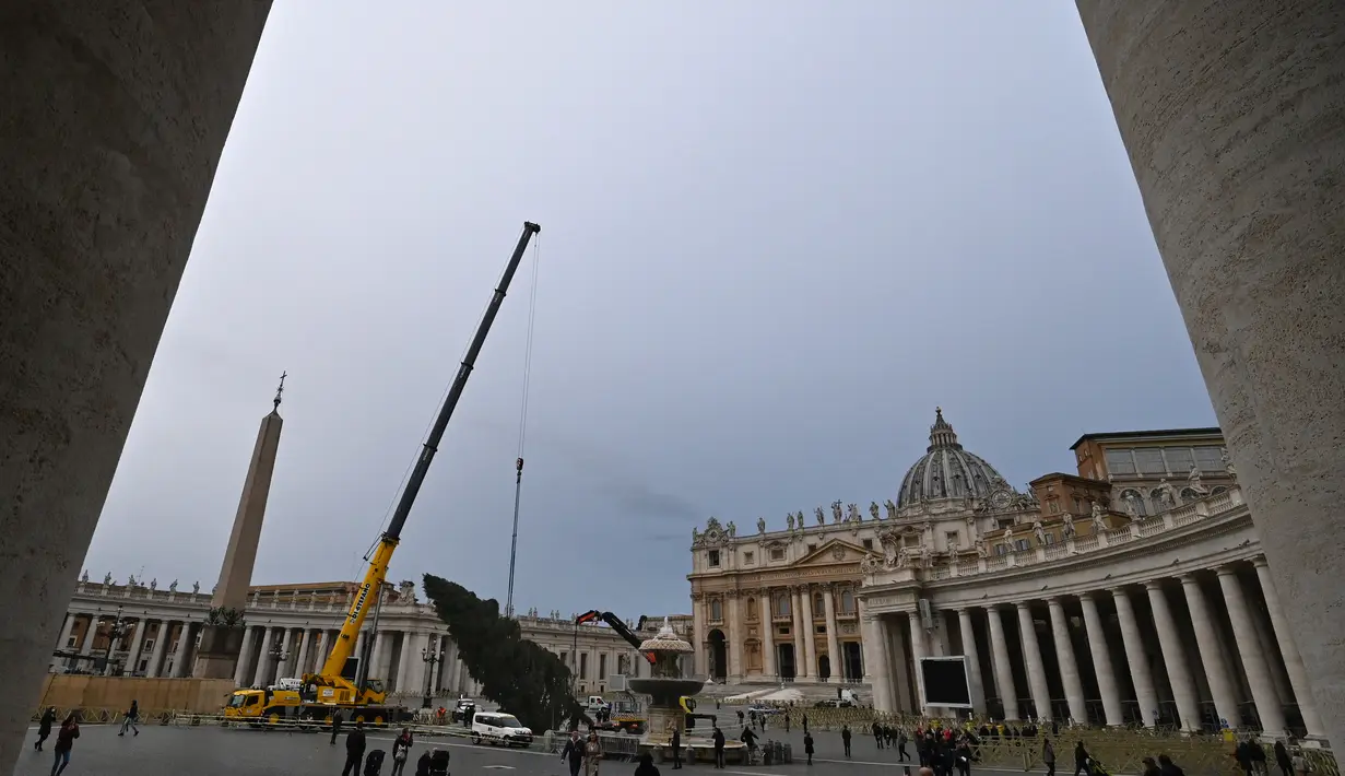 Sebuah derek mengangkat Pohon Natal setinggi 28 meter saat pemasangannya di Lapangan Santo Petrus, Vatikan, Selasa (23/11/2021). Pohon natal raksasa seberat 8 ton yang diambil dari hutan Andalo di wilayah Trentino, itu akan dinyalakan pada 10 Desember mendatang. (Alberto PIZZOLI / AFP)