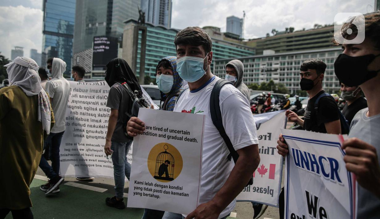 Ratusan imigran Afghanistan jalan kaki menuju Kedubes Kanada di Jakarta, Senin (13/12/2021). Dengan membawa spanduk dan poster, mereka menuntut UNHCR dan IOM segera memproses penempatan mereka ke negara tujuan seperti Kanada, Australia, Selandia Baru maupun AS. (Liputan6.com/Faizal Fanani)