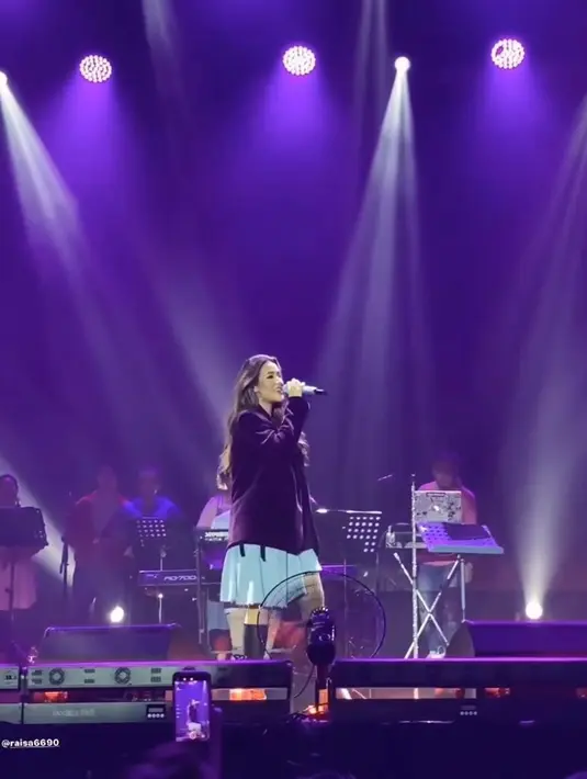 Raisa Andriana bergaya formal memadukan dress asimetris warna biru dan oversized jas warna hitam. Penampilannya dilengkapi dengan boots warna senada. [raisa6690]