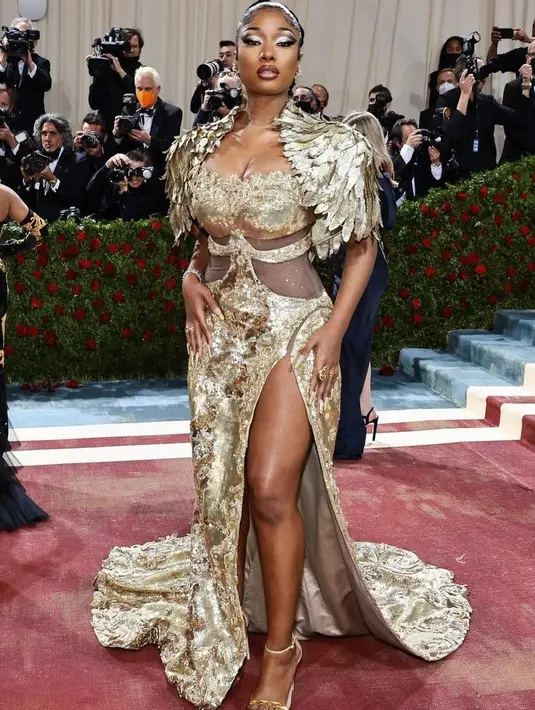 <p>Tampilan glamor nan mewah Megan Thee Stallion ini begitu mencuri perhatian. Dia mengenakan dress berlapis emas daari Moschino. (Instagram/metgalaofficial).</p>
