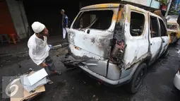Seorang pria mengecek kondisi mobil yang terbakar di Pecenongan, Jakarta, Sabtu (11/2). Kedua mobil tersebut diduga terbakar akibat bom molotov oleh orang tak dikenal pada Sabtu (11/2/2017) sekitar pukul 03.20 WIB. (Liputan6.com/Immanuel Antonius)