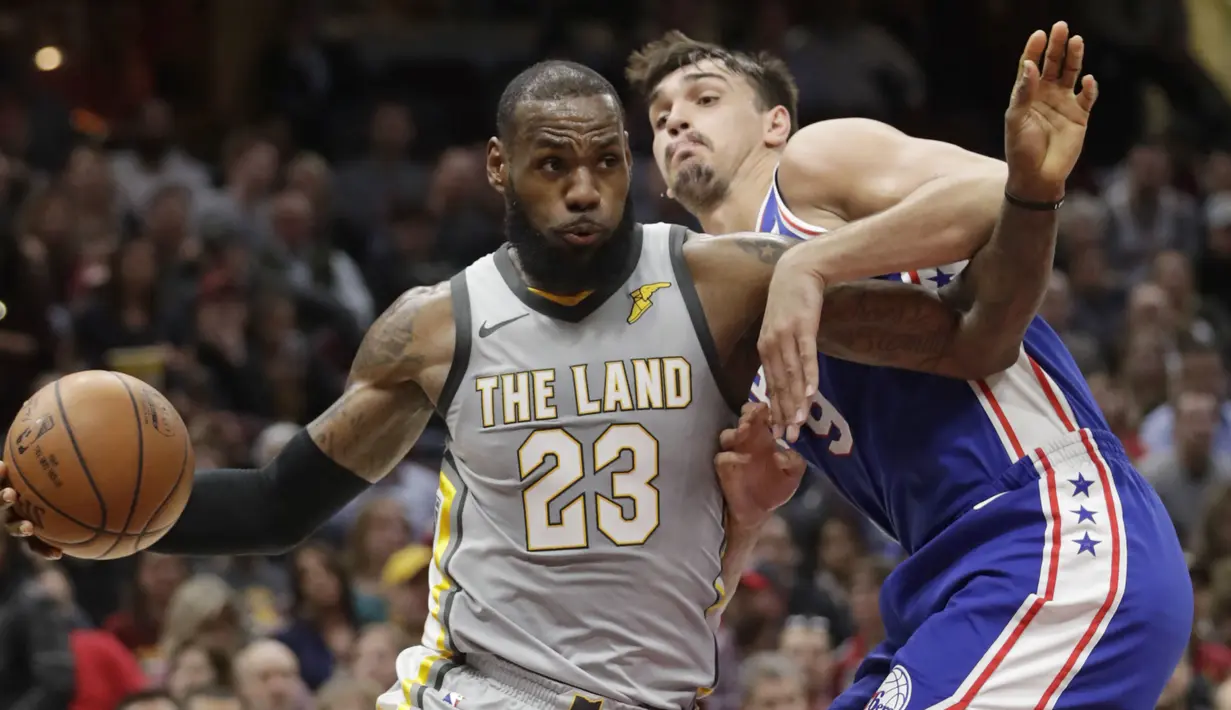 Aksi pemain Cleveland Cavaliers, LeBron James #23 melewati adangan pemain Philadelphia 76ers, Dario Saric #9 pada laga NBA basketball game di Quicken Loans Arena, Cleveland,  (1/2/2018).  Cavs kalah 97-108. (AP /Tony Dejak)