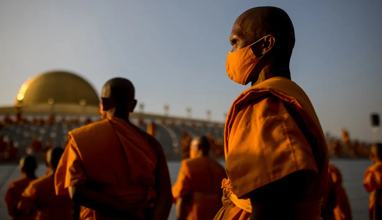 Para biksu Buddha bersiap untuk mengambil tempat sebelum beribadah pada perayaan Makha Bucha, di tengah pandemi COVID-19, di Wat Dhammakaya, utara Bangkok, Jumat (26/2/2021). Perayaan berlangsung pada bulan purnama, tiap bulan ketiga dalam penanggalan kalender Buddha. (Jack TAYLOR/AFP)