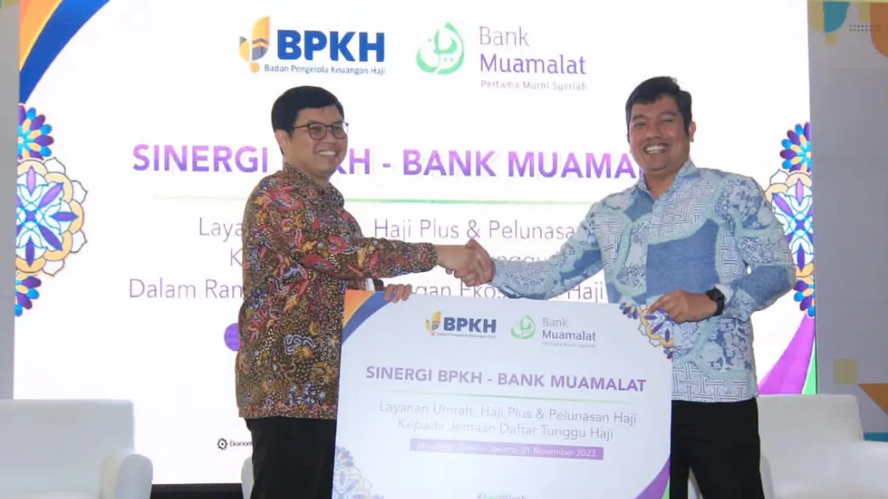 Anggota BPKH Harry Alexander (kanan) dan Direktur Utama Bank Muamalat Indra Falatehan (kiri) berfoto dengan memegang mockup Perjanjian Kerja Sama (PKS) layanan umrah, haji plus dan pelunasan haji kepada jemaah daftar tunggu di Jakarta, Selasa (21/11/2023)