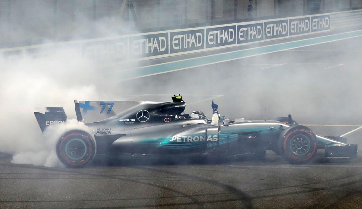 Aksi pebalap Mercedes, Valtteri Bottas melakukan drifting usai meraih podium pada balapan F1 Abu Dhabi di Yas Marina circuit , (26/11/2017). Bottas finis pertama. (AFP/Karim Sahib)