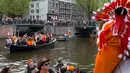 Warna nasional Belanda, oranye, mendominasi jalan dan kanal pada Hari Ulang Tahun Raja atau King's Day di Amsterdam, 27 April 2018. Hari Raja diselenggarakan untuk merayakan hari ulang tahun raja Belanda, Raja Willem Alexander. (AP/Peter Dejong)