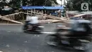 Kendaraan melintas di depan tumpukkan pohon pinang yang dijual di Jalan Manggarai Utara, Jakarta, Selasa (11/8/2020). Penjualan pohon pinang tahun ini menurun drastis dibandingkan tahun sebelumnya akibat pandemi Covid-19 yang menyebabkan larangan sejumlah perlombaan. (merdeka.com/Iqbal Nugroho)