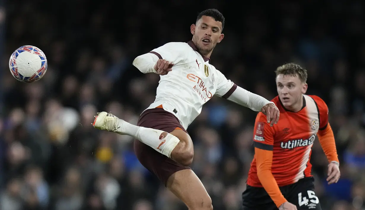 Gelandang Manchester City, Matheus Nunes (kiri) melepaskan umpan dengan tumitnya di depan Luton Town, Alfie Doughty pada laga putaran kelima Piala FA 2023/2024 di Kenilworth Road Stadium, Luton, Selasa (27/2/2024). (AP Photo/Alastair Grant)