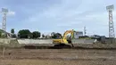 Sebuah ekskavator sedang melakukan renovasi pada bagian lapangan Stadion Gelora Kie Raha yang terletak di Ternate, Maluku Utara pada Kamis, (14/3/2024). Stadion tersebut akan menjadi markas bagi Malut United untuk Liga 1 musim depan. (Bola.com/Hery Kurniawan)