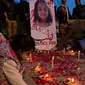 Seorang anak menaruh lilin untuk  Zainab Ansari, gadis 8 tahun yang diculik, diperkosa dan dibunuh di Islamabad, Pakistan (11/1). Sampai saat ini pelaku belum ditangkap. (AP Photo/B.K. Bangash)