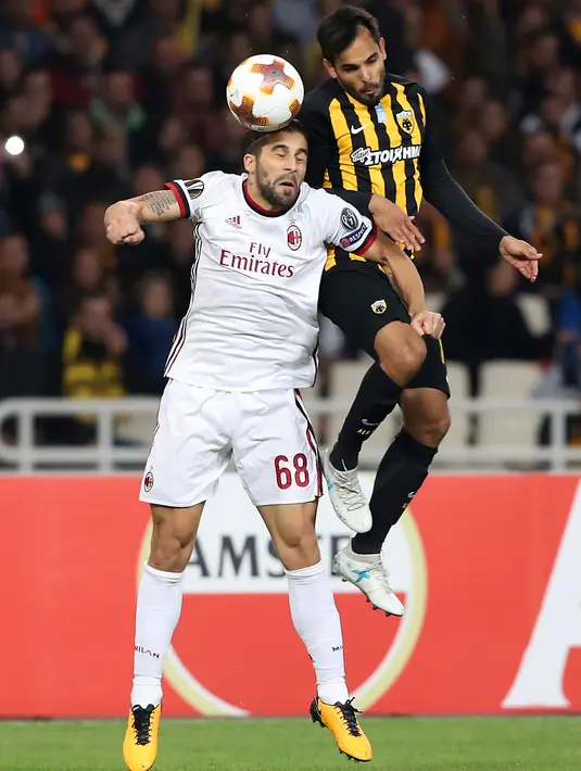 Pemain AC Milan, Ricardo Rodriguez melompat untuk merebut bola dari pemain AEK Athens, Rodrigo Galo pada laga lanjutan Grup D Liga Europa di Stadion Athens Olympic, Jumat (3/11). Milan dan AEK harus puas bermain imbang tanpa gol (AP/Petros Giannakouris)