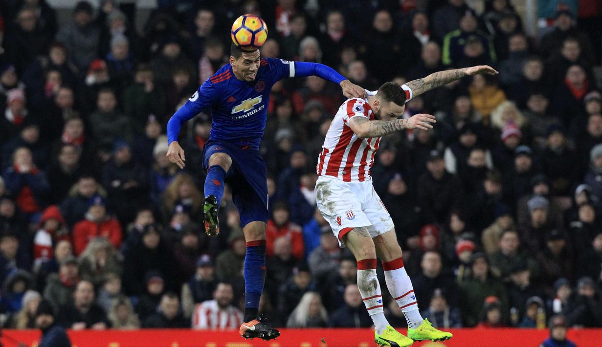Duel antara pemain Manchester United, Chris Smalling (kiri) dan pemain Stoke City pada lanjutan Premier League di Bet365 Stadium, Stoke-on-Trent, (21/1/2017). Setan Merah bermain Imbang 1-1. (AFP/Lindsey Parnaby)