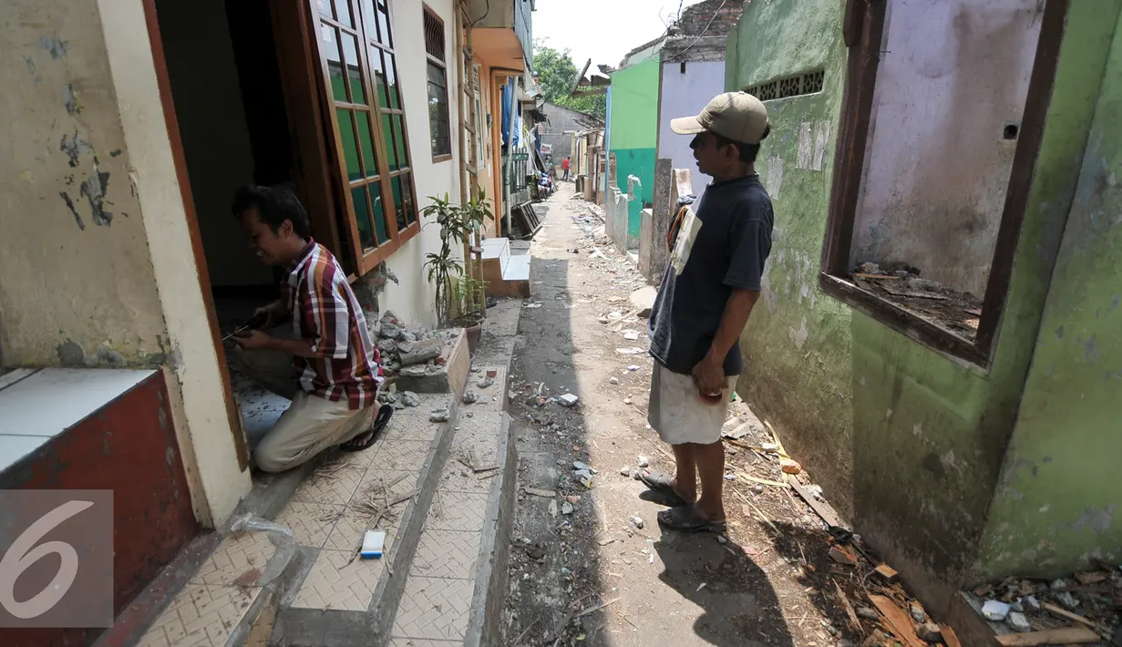 Warga Bukit Duri membongkar pintu rumahnya setelah mendapatkan SP 2 dari Pemprov DKI Jakarta, Rabu (7/9). Pemprov DKI layangkan Surat Peringatan (SP) 2 untuk warga Bukit Duri yang terdampak normalisasi Kali Ciliwung. (Liputan6.com/Yoppy Renato)