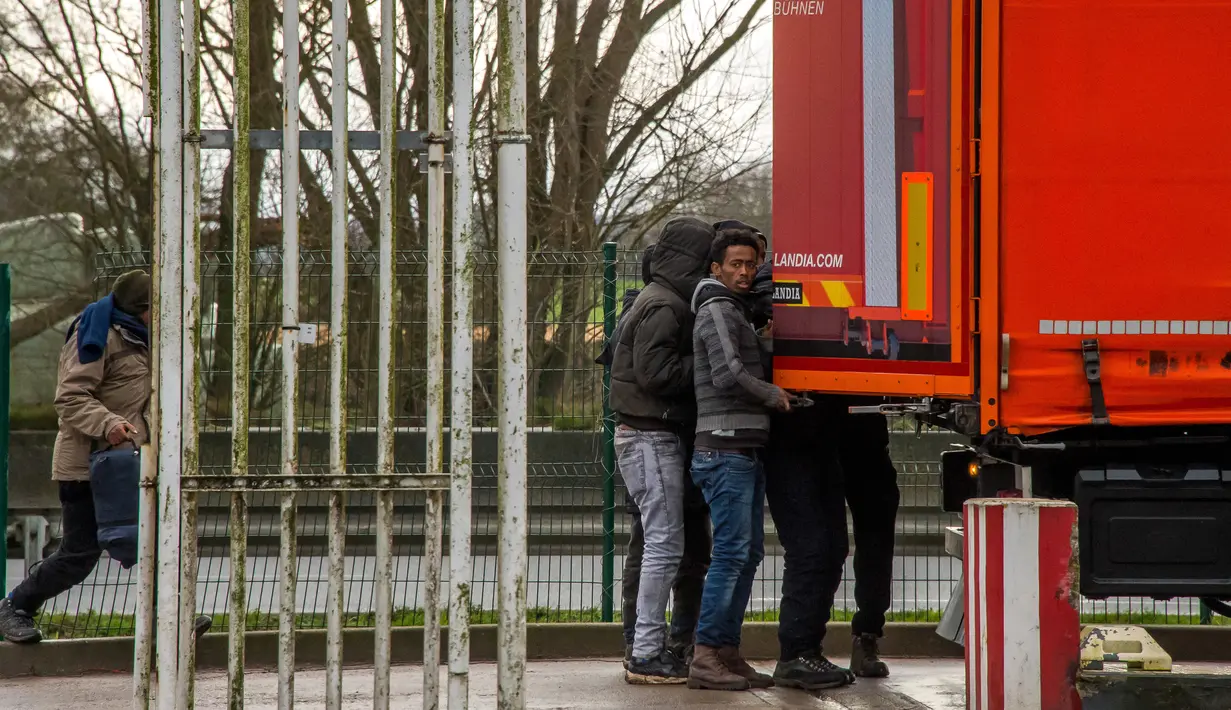 Sejumlah imigran saat ingin masuk ke dalam truk di A25 autoroute, Steenvoorde, Prancis (27/2). Para imigran ini nekat sembunyi saat menghindari kejaran petugas imigrasi. (AFP Photo / Philippe Huguen)
