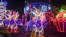 Pengunjung berpose di samping dekorasi Natal di Medellin, Kolombia (4/12). (AFP Photo/Joaquin Sarmiento)