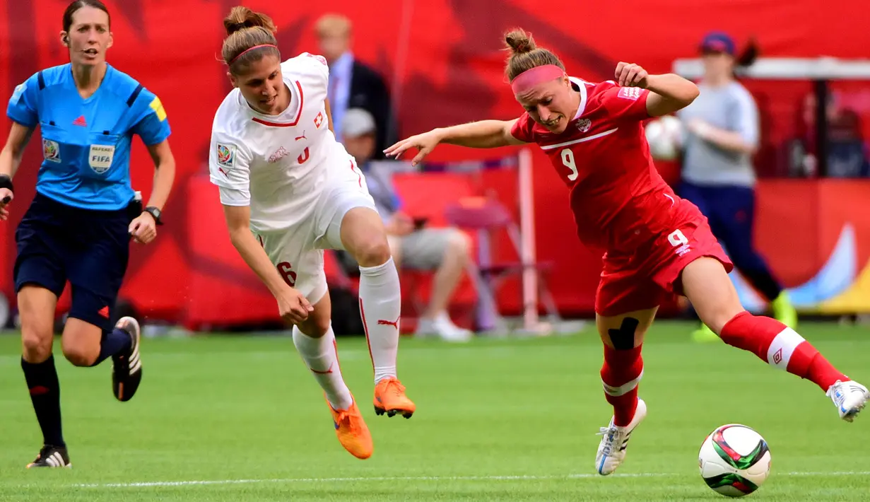 Bek Kanada, Josee Belanger (kanan)  berusaha melewati bek Swiss Selina Kuster saat Piala Dunia wanita 2015 di BC Place Stadium, Senin (22/6/2015). Kanada menang 1-0 atas Swiss lewat gol Josee Belanger. (Reuters/Anne Marie Sorvin)