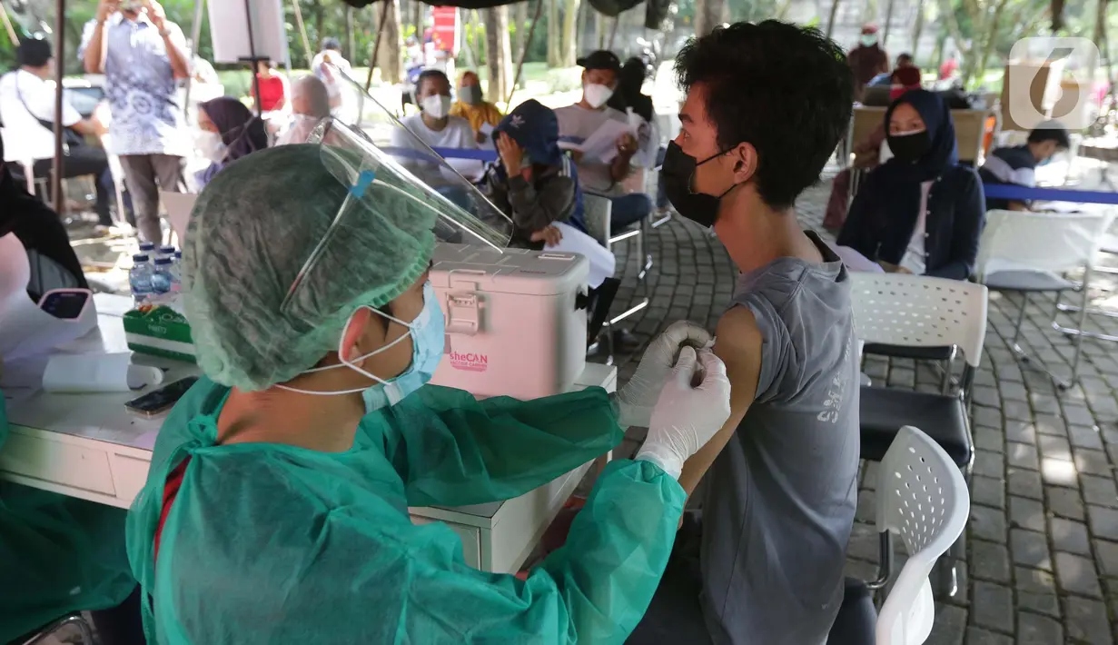 Vaksinator menyuntikkan vaksin COVID-19 untuk warga di Taman Dadap Merah, Kebagusan, Jakarta, Sabtu (10/7/2021).  Pelaksanaan vaksinasi melalui mobil vaksin keliling juga diperuntukkan untuk anak usia 12 tahun ke atas. (Liputan6.com/Helmi Fithriansyah)