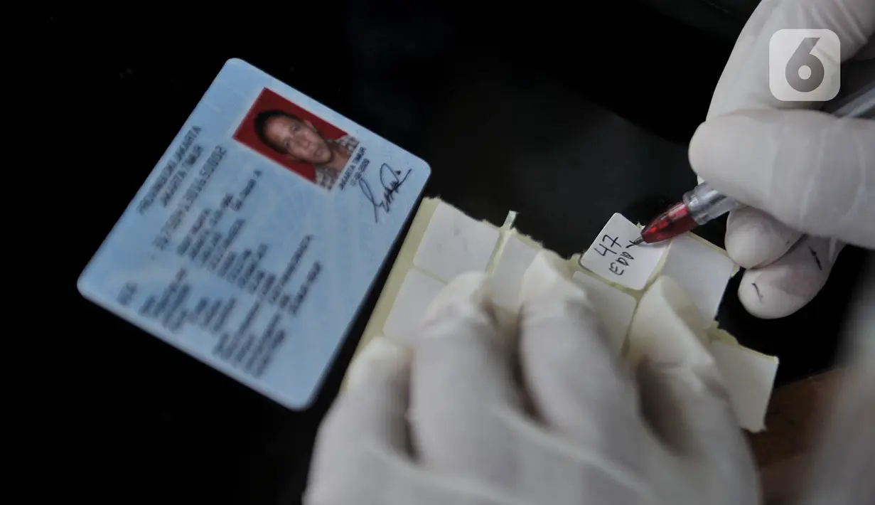 Petugas medis mendata salah satu pedagang sebelum menjalani Tes Swab Covid-19 di Pasar Kramat Jati, Jakarta, Rabu (17/6/2020). Ratusan pedagang Pasar Kramat Jati menjalani tes swab secara bertahap sebagai upaya pemerintah memutus rantai penyebaran virus Covid-19. (merdeka.com/Iqbal S. Nugroho)