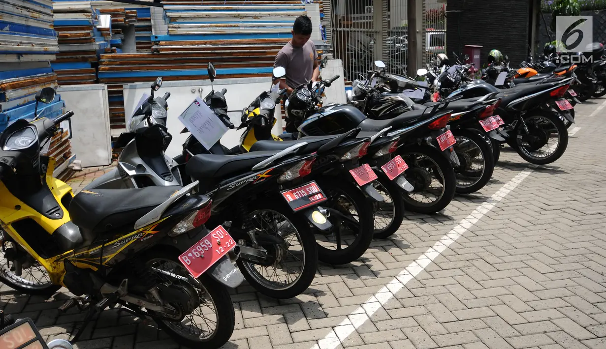 Petugas mengecek kondisi motor operasional KPK yang akan dilelang di Gedung KPK Lama, Jakarta, Selasa (27/2). KPK akan melelang kendaraan operasional inventaris yang telah berumur di atas 10 tahun. (Liputan6.com/Helmi Fithriansyah)