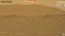 Rekaman video yang dibuat dari siaran langsung NASA pada 19 April 2021 ini menunjukkan helikopter Ingenuity terbang di atas permukaan Mars. NASA berhasil menerbangkan helikopter Ingenuity di Mars pada 19 April. (NASA/AFP)