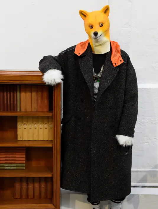 Seorang model mengenakan topeng anjing berpose saat membawakan kreasi Julien David untuk koleksi Fall / Winter 2018/2019 dalam Paris Men Fashion Week di Paris (17/1). (AFP Photo/Bertrand Guay)