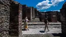 Orang-orang mengunjungi situs arkeologi Pompeii seusai kebijakan lockdown selama dua bulan untuk mengendalikan penyebaran Covid-19 di Italia, Selasa (26/5/2020). Salah satu situs arkeologi paling terkenal di dunia ini dibuka kembali untuk umum pada 26 Mei. (Tiziana FABI / AFP)