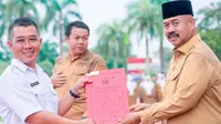 Taufiq Hidayat, guru SD di pedalaman Kutai Kartanegara tampak bahagia menerima SK pengangkatan sebagai ASN lewat Pegawai Pemerintah dengan Perjanjian Kerja (PPPK). SK tersebut diberikan langsung oleh Bupati Kutai Kartanegara Edi Damansyah. (foto: istimewa)