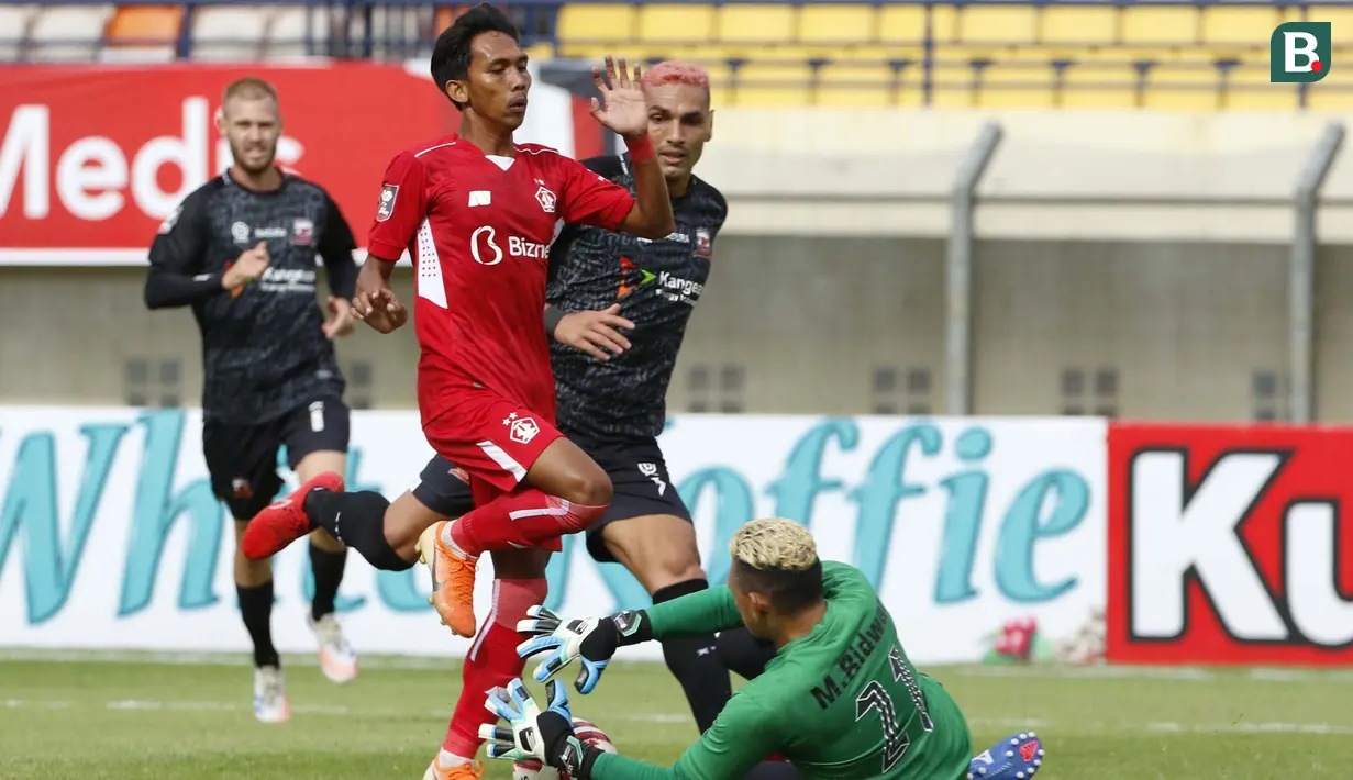 Penjaga gawang Madura United, Muhammad Ridwan berhasil mengamankan bola dari ancaman pemain Persik Kediri dalam laga Grup C Piala Menpora 2021 di Stadion Si Jalak Harupat, Bandung, Sabtu (3/4/2021). (Bola.com/Ikhwan Yanuar)