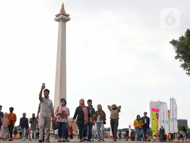 Warga berwisata mengunjungi kawasan wisata Monumen Nasional (Monas) di Gambir, Jakarta Pusat, Jumat (30/6/2023). (Liputan6.com/Angga Yuniar)