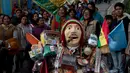 Sejumlah orang berada didekat patung dewa Ekeko yang dipenuhi dengan aneka barang saat arak-arakan di La Paz, Bolivia (23/1). Organisasi PBB, UNESCO mengumumkan Alista merupakan warisan tak berwujud pada Desember 2017. (AP Photo / Juan Karita)