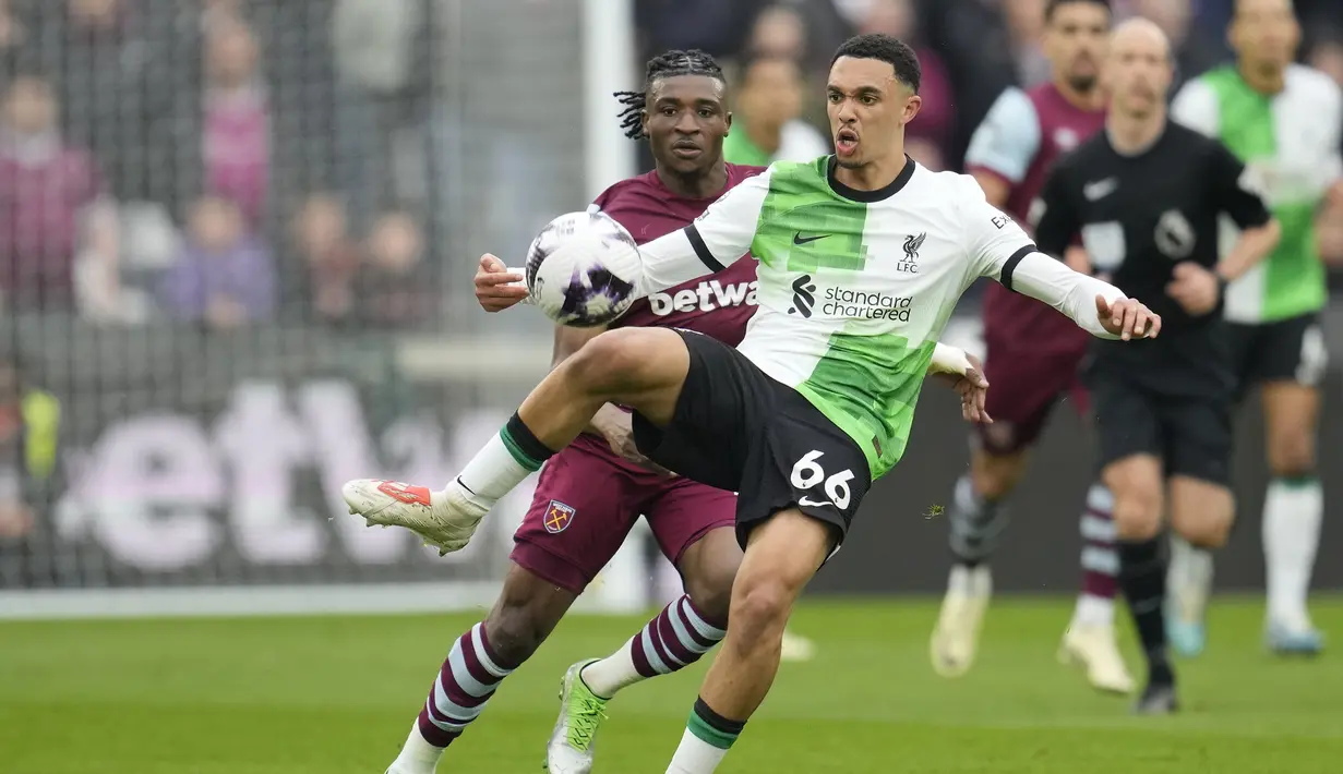 Bek Liverpool, Trent Alexander-Arnold (depan) mengontrol bola dibayangi gelandang West Ham United, Mohammed Kudus pada laga pekan ke-35 Premier League 2023/2024 di London Stadium, London, Sabtu (27/4/2024). (AP Photo/Kin Cheung)