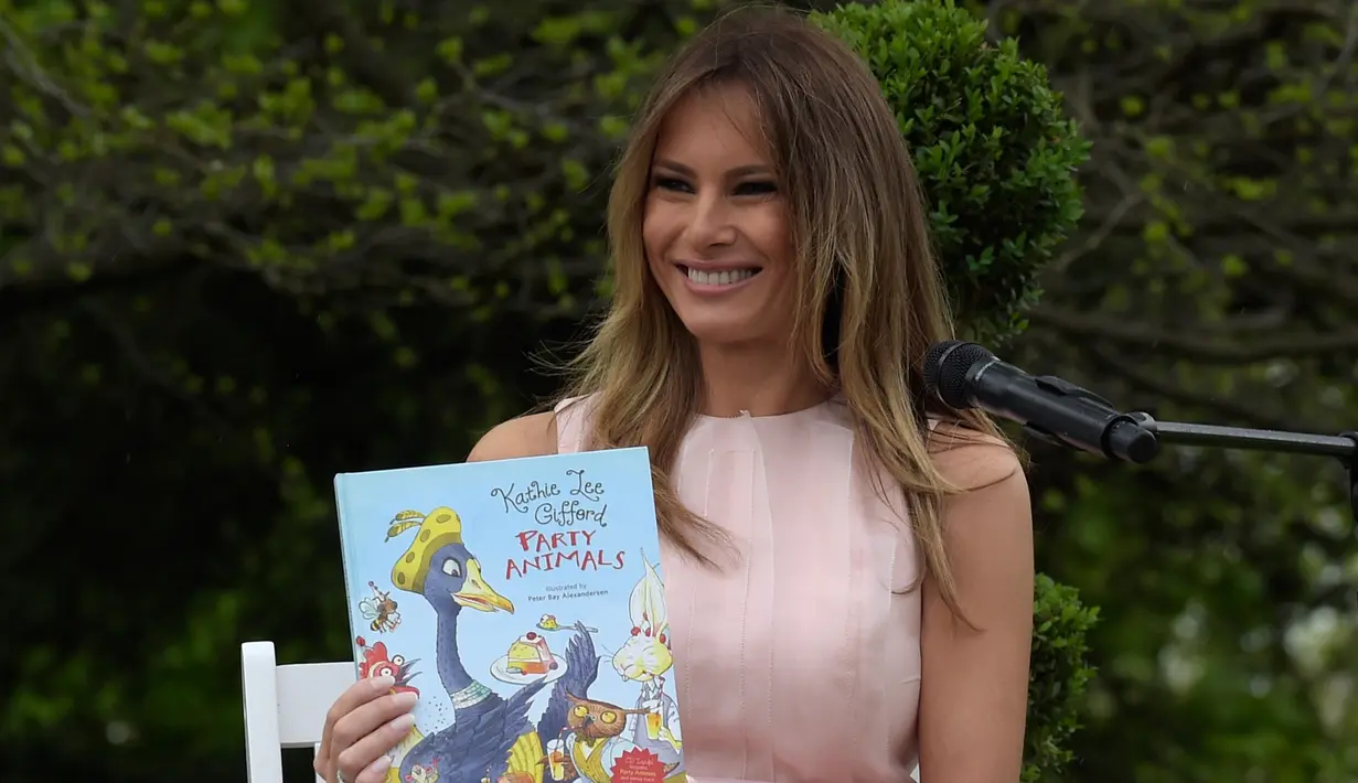 Melania Trump menunjukan buku cerita anak "Party Animals" saat perayaan Paskah ke-139 di halaman selatan Gedung Putih, Washington, Senin (17/4). (AP Photo/Carolyn Kaster)