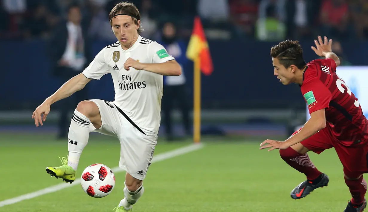 Gelandang Real Madrid, Luka Modric mengontrol bola dari kawalan pemain Kashima Antlers, Abe Hiroki selama semifinal Piala Dunia Antarklub 2018 di stadion Zayed Sports City, Uni Emirat Arab (19/12). Madrid menang 3-1. (AP Photo/Kamran Jebreili)