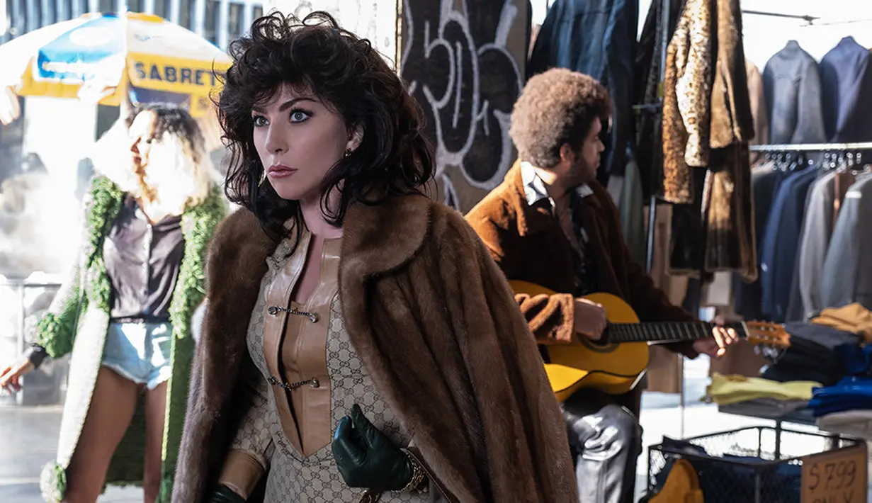 Ia juga mengenakan setelan Gucci archive dengan setelan otentik, dengan motif print monogram dan coat berbulu mink.