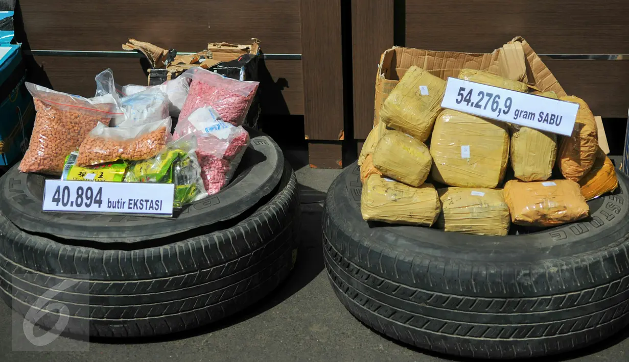 Petugas memperlihatkan barang bukti sabu dan pil ekstasi yang berhasil diamankan oleh BNN, Jakarta, Jumat (13/5). 54 kg sabu dan 40 ribu butir pil ekstasi yang disita dari jaringan internasional itu disimpan di ban serep mobil. (Liputan6.com/Yoppy Renato)