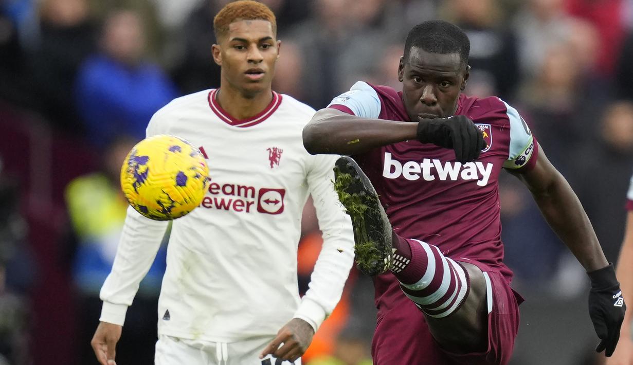 Bek West Ham United, Kurt Zouma menghalau bola di depan striker Manchester United, Marcus Rashford pada laga pekan ke-18 Liga Inggris 2023/2024 di London Stadium, London, Sabtu (23/12/2023). (AP Photo/Kirsty Wigglesworth)