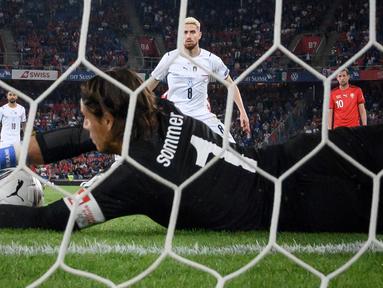 Kiper Swiss, Yann Sommer tampil cemerlang saat menahan Italia 0-0 dalam laga Kualifikasi Piala Dunia 2022 Grup C Zona Eropa di St Jakob-Park Stadium, Basel, Minggu (5/9/2021). Sejumlah peluang Italia berhasil dipatahkan termasuk eksekusi penalti Jorginho. (Foto: AFP/Fabrice Coffrini)
