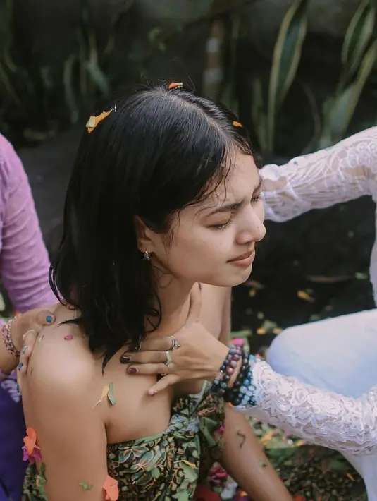 Didampingi warga adat Bali, Aurelie terlihat khidmat mengikuti ritual ini. Aurelie mengenakan batik khas Bali yang membuatnya tampil eksotik. Ia juga menjelaskan fungsi Melukat yang berkenaan dengan kesehatan mental. (Liputan6.com/IG/aurelie)