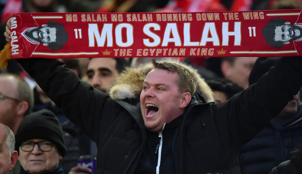 Seorang pendukung Liverpool memegang spanduk dukungan untuk Mohamed Salah saat menyaksikan pertandingan melawan Manchester City di Liga Champions di Anfield, Liverpool (4/4). (AFP Photo/Anthony Devlin)