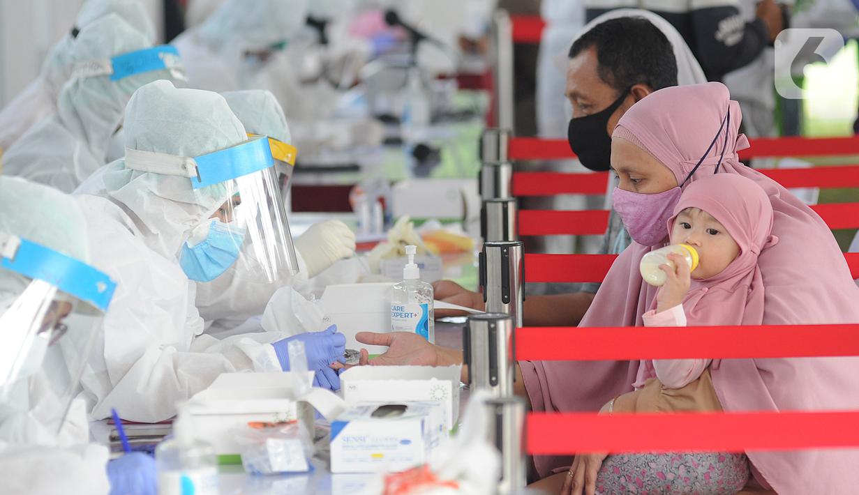 Petugas medis memeriksa warga saat rapid test oleh BIN di Lapangan Kantor Kecamatan Pamulang, Tangerang Selatan, Banten, Kamis (2/7/2020). BIN menggelar rapid test gratis terhadap 800 warga Pamulang untuk memutus mata rantai penyebaran virus corona COVID-19. (merdeka.com/Arie Basuki)