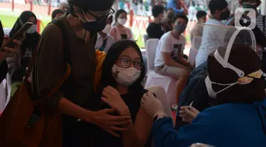 Seorang ibu mendampingi anaknya melakukan vaksin covid-19 di Stadion Utama Gelora Bung Karno (GBK), Senayan, Jakarta, Sabtu (3/7/2021). Pemprov DKI menggelar vaksinasi COVID-19 massal bagi anak usia 12-17 tahun di Stadion GBK selama dua hari, yakni pada 3-4 Juli 2021. (merdeka.com/Imam Buhori)