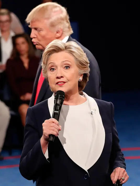 Tingkah aneh Donald Trump yang berdiri di belakang Hillary Clinton selama debat Capres AS putaran kedua yang diadakan di Washington University, St Louis, AS, Minggu (9/10). (AP Photo/ Rick T. Wilking)