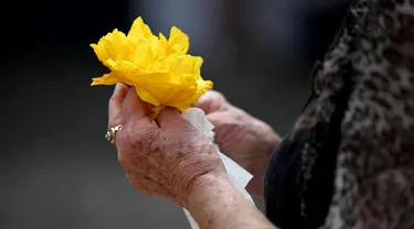 Seorang perempuan memegang bunga di Monumen Kemanusiaan Ground Zero bagi para korban untuk memperingati 20 tahun bom Bali yang menewaskan lebih dari 200 orang, di Kuta, Bali, Rabu (12/10/2022). Peristiwa Bom Bali I telah memasuki tahun ke-20. (SONNY TUMBELAKA / AFP )